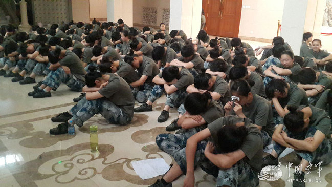 排练间隙，乐队的官兵们坐在地上休息片刻。
