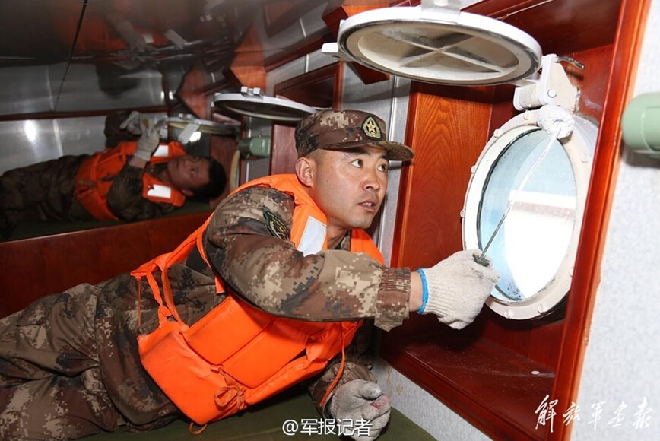 战士们对巡逻艇进行维护保养.