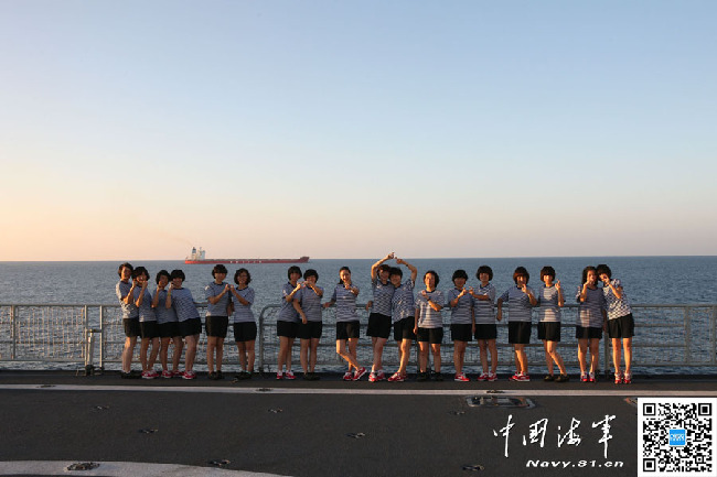 对着镜头，女兵们做出“9”的手势，999是这艘舰的舷号，她们身后不远处是被护商船。亚丁湾上，留下了这群女兵的青春记忆