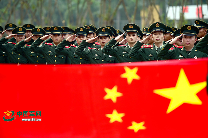 图为武警广东省边防总队机动支队临退伍老兵向国旗敬礼告别.