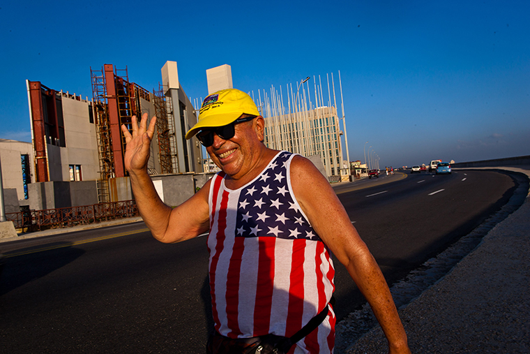 哈瓦那的美国驻古巴使馆前,一名身穿美国国旗图案背心的老人挥手示意