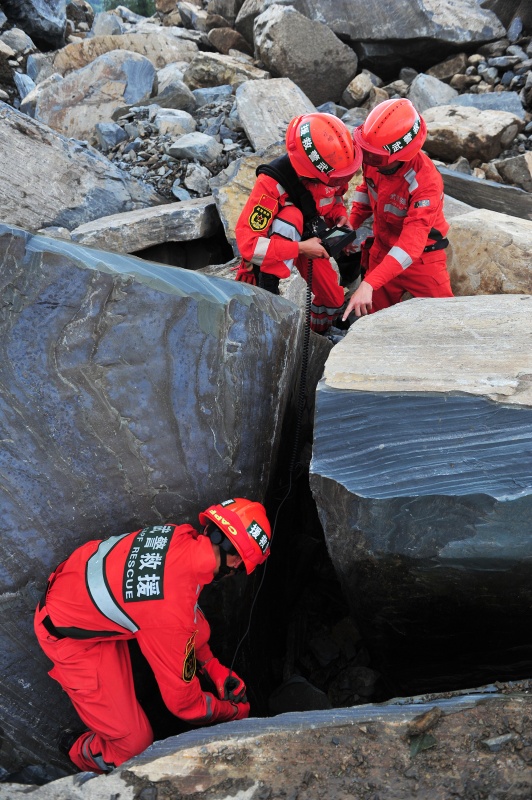 8月28日,武警救援人员在现场使用生命探测仪进行搜救.