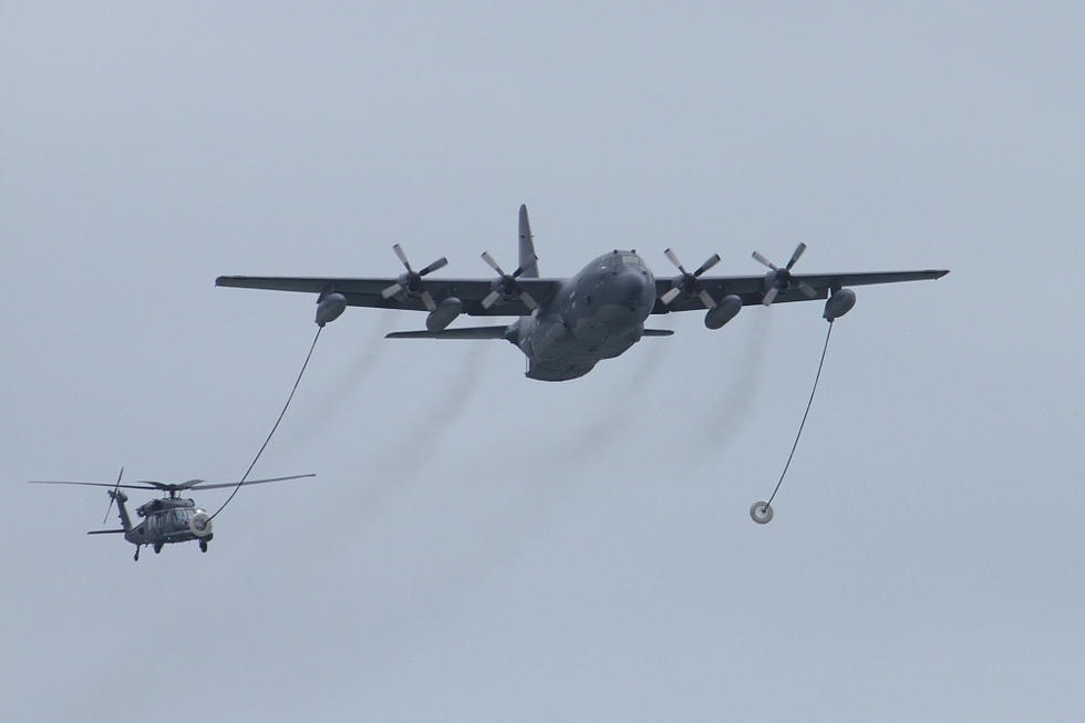 空军救援部队的hc-130加油/运输机为hh-60g救援直升机进行空中加油