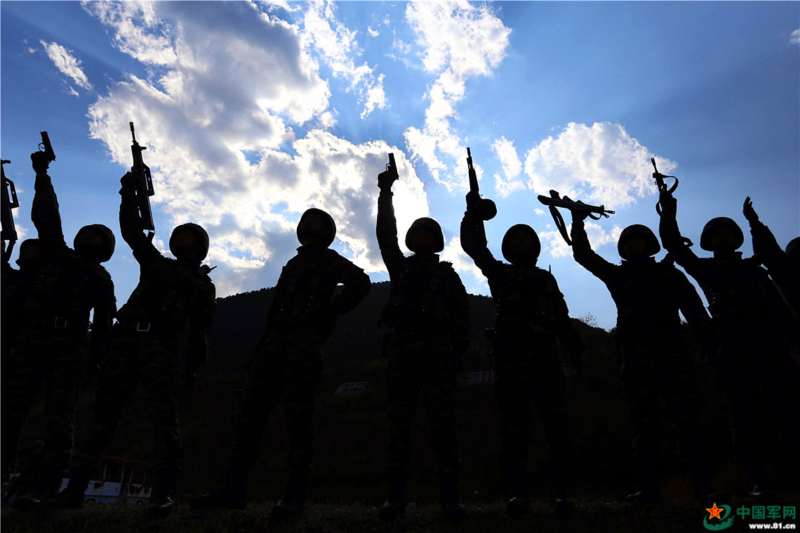 夕阳西下,训练一天的武警官兵打靶归来,他们身着戎装,手持钢枪的身影