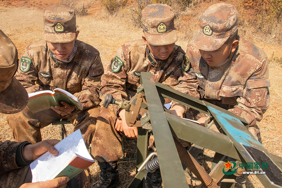 "该旅"英雄营"高级坦克驾驶员曾明军正在考察"萌新"们的理论学习情况.