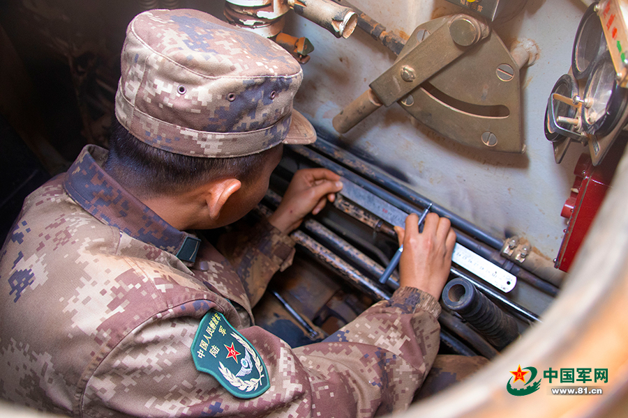 "该旅"英雄营"高级坦克驾驶员曾明军正在考察"萌新"们的理论学习情况.