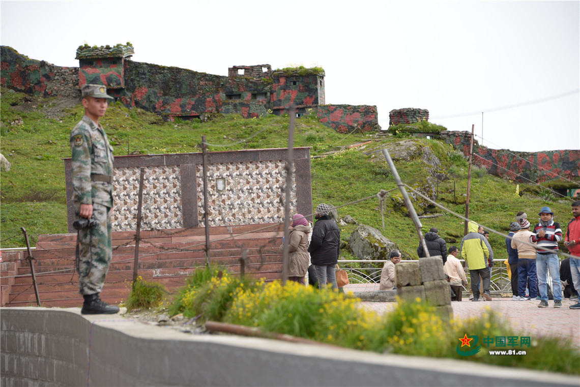 在乃堆拉山口执勤的中国边防官兵,国境线附近是印度游客(8月1日摄)刘