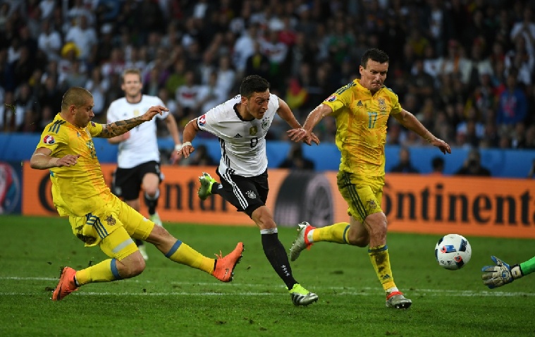 6月12日,德国队球员厄齐尔(中)在比赛中射门.