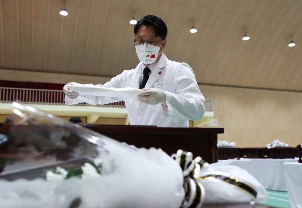 9月1日,在韩国仁川,韩方工作人员将志愿军烈士遗骸入殓.